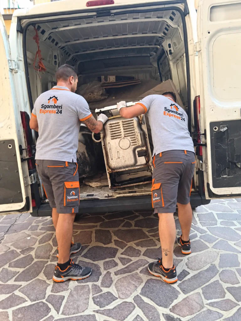 Due operatori di Sgomberi Express24 caricano materiale ingombrante sul furgone durante lo sgombero a Milano Maciachini